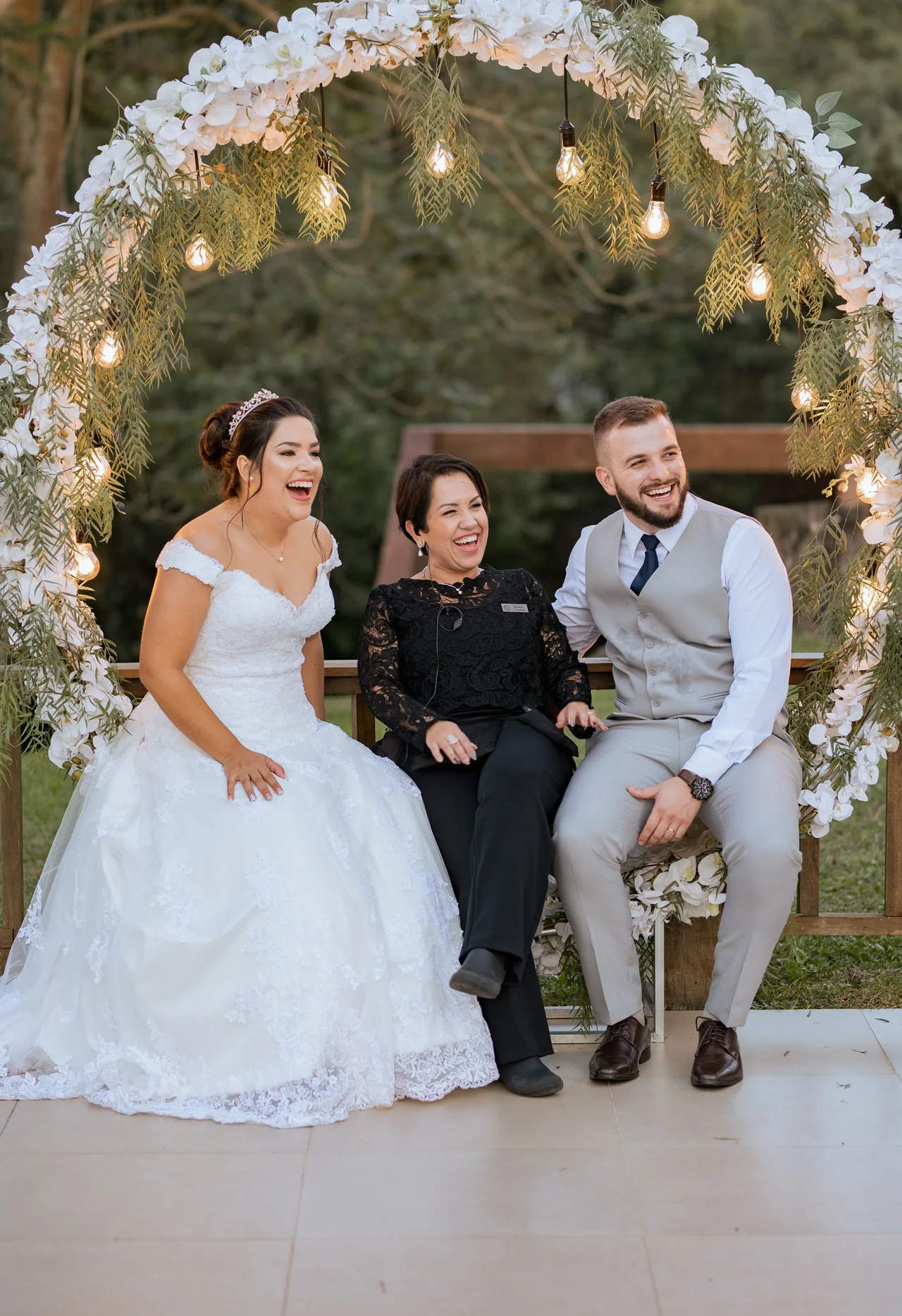Juliana Porto sorrindo com o casal nos bastidores.