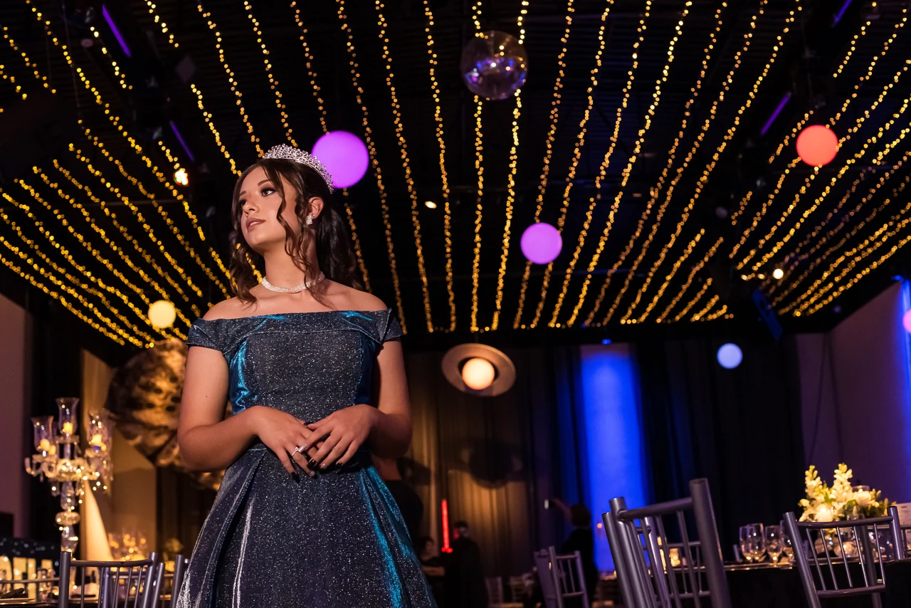 Debutante diante das luzes da celebração de 15 anos.