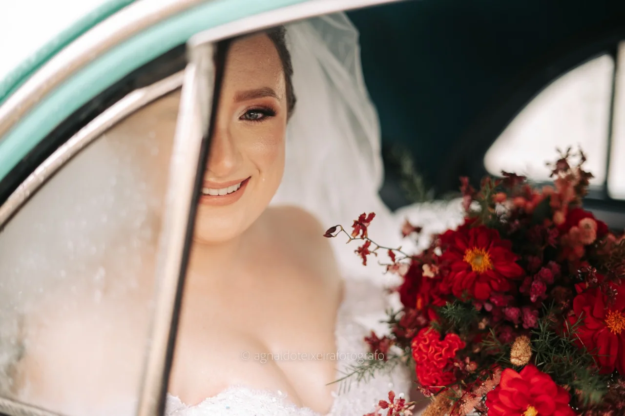 Noiva sorrindo no carro antes da cerimônia.