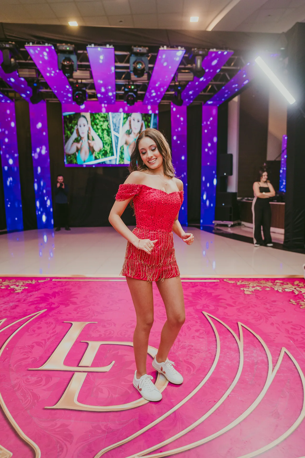 Debutante de vestido vermelho na pista de dança.