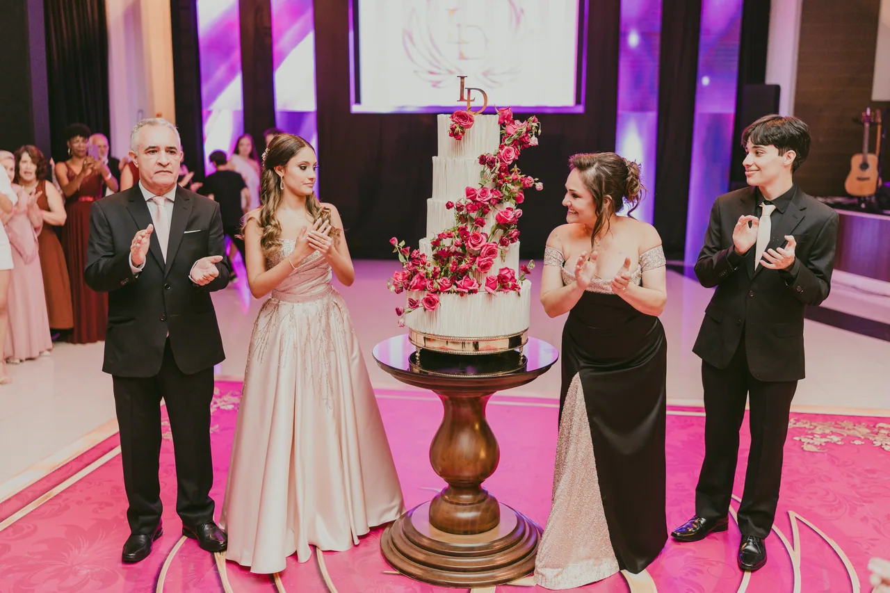 Debutante com a família diante do bolo.