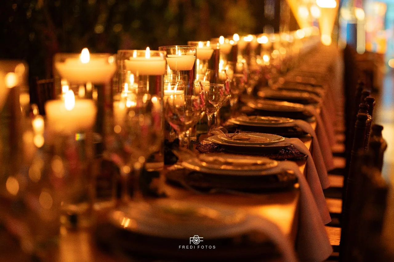 Mesa de recepção iluminada por velas.
