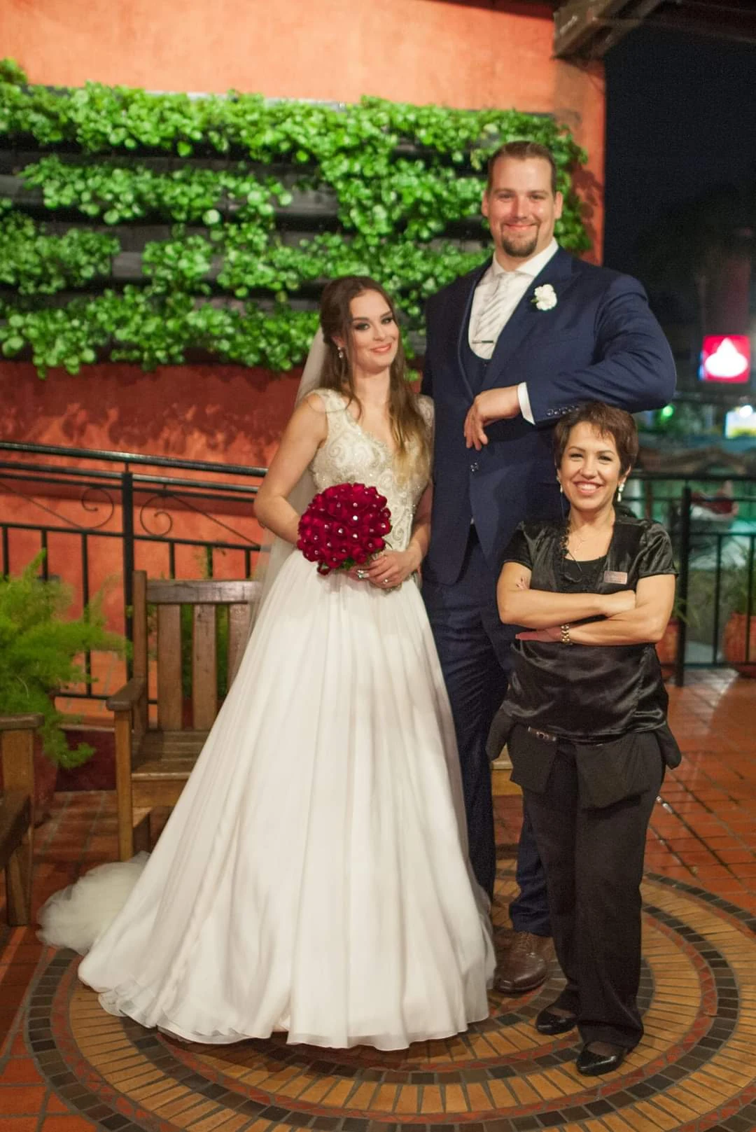 Juliana Porto ao lado da noiva e do noivo em um casamento real.